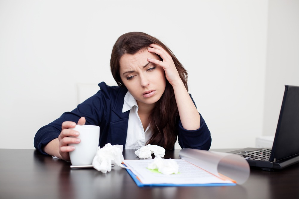 Donna malata al lavoro che beve caffè