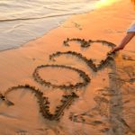 Una donna che scrive numeri sulla sabbia con la mano